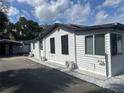 Side of the home featuring white siding, black roof, and a carport at 610 Illinois Ave, St Cloud, FL 34769