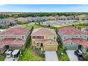 An aerial view of a two-story home in a Gathering-friendly community, complete with landscaping and attached garages at 7622 Oakmoss Loop, Davenport, FL 33837