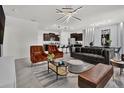 Spacious living room featuring modern lighting fixtures, a large sofa, stylish furniture and an open floor plan at 7622 Oakmoss Loop, Davenport, FL 33837