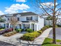 Townhome featuring blue shutters, neutral paint, manicured landscaping, and driveway at 7682 Fitzclarence St, Kissimmee, FL 34747