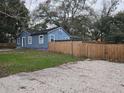 Cozy blue home featuring a fenced yard for privacy and a spacious driveway for convenient parking at 7709 Bell Blvd, Orlando, FL 32810