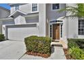 Close up of front door featuring well-kept lawn, neat shrubs and a two-car garage at 7761 Tosteth St, Kissimmee, FL 34747