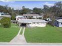 An aerial view of a charming single-story home with a well-manicured lawn and a convenient covered carport at 8101 Dominguin St, Orlando, FL 32817