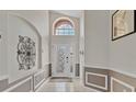 Open-concept foyer with tile flooring, decorative wall art, and large transom window above the front door at 8103 Yellow Crane Dr, Kissimmee, FL 34747