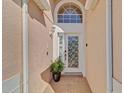 Close-up of a front door featuring decorative glass, sidelights, and a stylish exterior light fixture at 8103 Yellow Crane Dr, Kissimmee, FL 34747