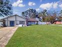 Inviting single-story home featuring a lush green lawn, stone accents, and bright blue front door at 830 E Flag Ln, Kissimmee, FL 34759