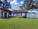 Charming home featuring a well-maintained lawn, stone details, and a white picket fence at 830 E Flag Ln, Kissimmee, FL 34759