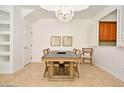 Bright dining room with modern chandelier, large table set, and peek-through window to kitchen at 8766 The Esplanade # 23, Orlando, FL 32836