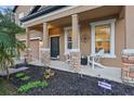 Inviting front porch with brick pillars, seating, landscaping, and a security system for peace of mind at 1894 Valley Forge Dr, St Cloud, FL 34769