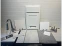 Close-up of design selection samples featuring cabinet door, tile, and fixtures on a white countertop at 1115 Olivine Ave, Dundee, FL 33838