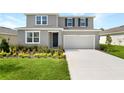 Charming two-story home featuring a two-car garage, beautiful landscaping, and a welcoming front entrance at 1127 Olivine Ave, Dundee, FL 33838