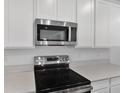 Modern kitchen featuring stainless steel microwave and stove and light countertops at 1127 Olivine Ave, Dundee, FL 33838