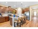 Stylish eat-in kitchen featuring stainless steel appliances, island with bar seating and wood flooring at 1131 Olivine Ave, Dundee, FL 33838