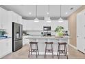 Modern kitchen featuring stainless steel appliances, white cabinets, and an island with barstool seating at 1135 Olivine Ave, Dundee, FL 33838