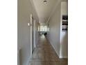 Inviting hallway with tiled floors leading to the living area with natural light; perfect for a welcoming entrance at 12369 Sawgrass Prairie Loop, Orlando, FL 32824