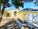 Inviting yellow single-Gathering home with a well-maintained lawn and a two-car garage in a friendly neighborhood at 12622 Earnest Ave, Orlando, FL 32837