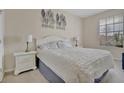 Bright bedroom featuring a plush white comforter, matching end tables, and natural light from a window at 1357 Venezia Ct # 302, Davenport, FL 33896