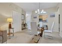 Open-concept dining room features a glass table, modern white chairs, and a view of the adjacent kitchen at 1357 Venezia Ct # 302, Davenport, FL 33896