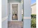 Inviting entryway with brick-paved porch and a glimpse into the home's open layout at 1873 Flora Pass Pl, Kissimmee, FL 34747