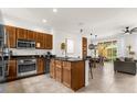 Modern kitchen with stainless steel appliances and granite countertops seamlessly flowing into the dining and living areas at 2634 Corvette Ln, Kissimmee, FL 34746