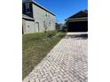 Long brick paver driveway leading to a one-story home with a well-manicured lawn at 2638 Eagle Canyon N Dr, Kissimmee, FL 34746