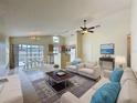 Living room showcasing tile flooring, ceiling fan, and views of kitchen and the pool at 2993 Kokomo Loop, Haines City, FL 33844