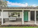 Charming covered porch with a swing, leading to a vibrant teal front door at 3004 Lake Margaret Dr, Orlando, FL 32806