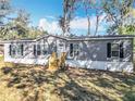 Charming single-story home featuring a gray exterior, black shutters, and a well-maintained front yard at 6189 Nw 68Th St, Ocala, FL 34482