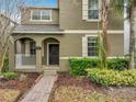 Two-story home featuring lush landscaping, beige shutters and a brick walkway at 6441 Point Hancock Dr, Winter Garden, FL 34787