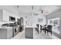 Bright kitchen features stainless appliances, white cabinets and a kitchen island at 6921 Long Needle Ct, Orlando, FL 32822