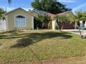 Charming single-story home featuring a well-manicured lawn, a two-car garage and lush tropical landscaping at 701 Swallow Ln, Poinciana, FL 34759