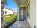 Welcoming front entrance with a stylish glass paneled door, clean pavers, and freshly trimmed landscaping at 732 Aldenham Ln, Ormond Beach, FL 32174