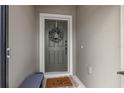 Stylish gray front door with decorative wreath, welcome mat and bench for guests at 747 Citrus Isle Dr, Davenport, FL 33837