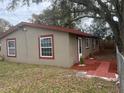 Angled side view of home showing windows, door, landscaping and stucco exterior at 888 Berkley Rd, Auburndale, FL 33823