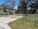 A view of the fenced-in front yard with a concrete driveway at 888 Berkley Rd, Auburndale, FL 33823