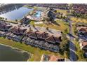 Aerial view of resort townhomes with lake, community pool, tennis courts, and parking at 8949 Candy Palm Rd, Kissimmee, FL 34747