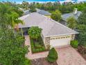 Beautiful single-story home showcasing a well-manicured lawn, tropical landscaping, and brick paved driveway at 100 Ventana Dr, Kissimmee, FL 34759