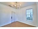 Bright room featuring wood floors, a stylish light fixture, and a window view at 1111 Oscar Sq, Celebration, FL 34747