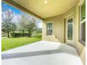 Spacious covered back patio overlooking a lush green lawn and mature trees at 12880 Westside Village Loop, Windermere, FL 34786