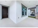 Inviting front porch featuring a window, stylish front door, and serene view of the backyard at 12971 Westside Village Loop, Windermere, FL 34786