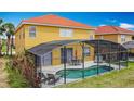 Backyard view of a screened-in pool and patio with outdoor dining set and lounge chairs at 131 Stella Pass, Davenport, FL 33837
