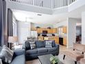 Open-concept living room with high ceilings, tile flooring, and view to the kitchen at 131 Stella Pass, Davenport, FL 33837