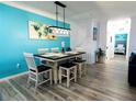 Open concept dining area with modern light fixture, bright blue walls, and seating for six at 1351 Tuscan Ter # 8408, Davenport, FL 33896