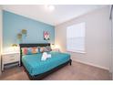 Bedroom with turquoise accent wall, queen bed and matching nightstands at 4138 Lana Ave, Davenport, FL 33897