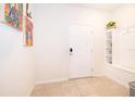 Bright entryway with neutral tile flooring, built-in shelving and a white front door at 4138 Lana Ave, Davenport, FL 33897