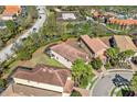 An aerial view of a home with a screened pool, well maintained landscaping, and a tile roof at 5512 Solterra Cir, Davenport, FL 33837