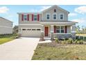 Two-story home with stone accents, red shutters, front porch, and attached two-car garage at 570 Summit River Dr, Apopka, FL 32712