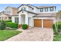 A beautiful two-story home with a paver driveway, two-car garage, manicured lawn, and beautiful landscaping at 6974 Trellis Vine Loop, Windermere, FL 34786