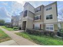 Exterior view of the condo building featuring well-maintained landscaping and a welcoming entrance area at 8137 Claire Ann Dr # 203, Orlando, FL 32825