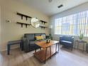 Bright living room with modern furniture, laminate flooring, and a large window at 8137 Claire Ann Dr # 203, Orlando, FL 32825